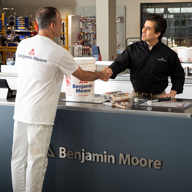 A local Benjamin Moore store professional sells paint and supplies to a painting contractor.