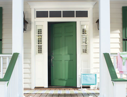 Green front door with matching window shutters