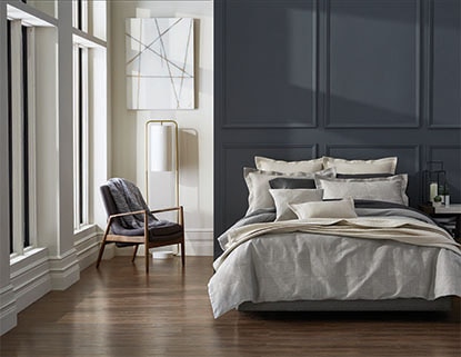 A bold accent wall complements a navy and gray bedding set