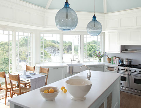 Bright, airy light blue kitchen with center island and cliffside view.