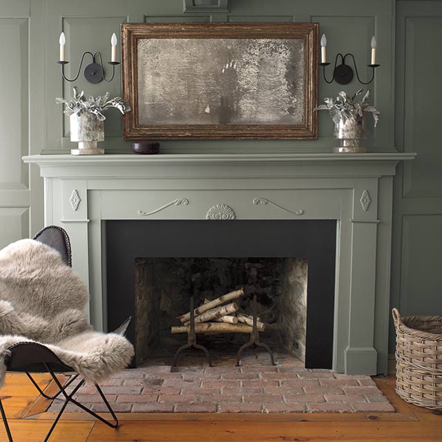 Olive green-painted walls with a light pink-painted ceiling and a muted green fireplace mantle.