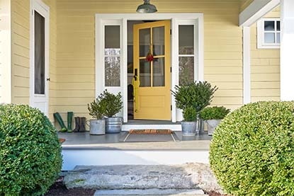 A bright and welcoming yellow front door painted in Stuart Gold HC-10.