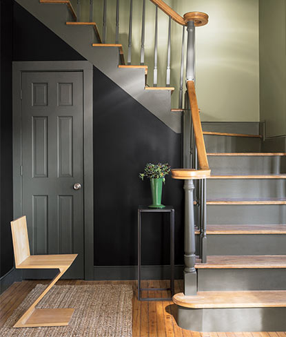 A dark blue-painted traditional entryway takes a twist with modern accents.