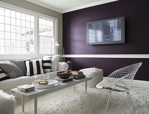 Un mur d’accent violet foncé avec téléviseur à écran plat dans un salon de style contemporain.