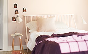 Chambre à coucher avec lit à une place, couverture mauve et mur recouvert de Matin Brumeux 2106-70.