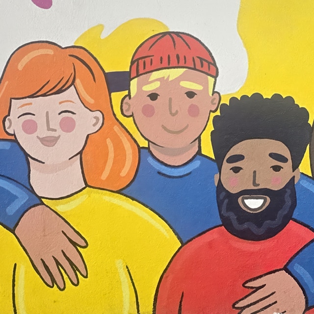 A colorful painted mural of people posing together.