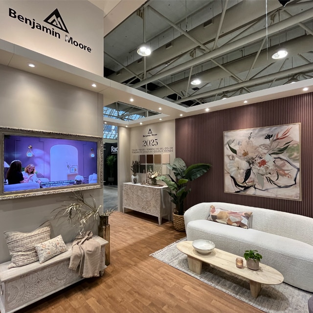 A showroom displaying Benjamin Moore’s 2025 Color Trends and Color of the Year, Cinnamon Slate, painted on a wall, with neutral furnishings and decor.