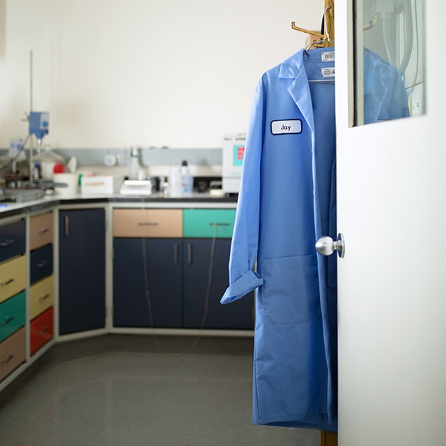 A blue lab coat hanging on a coat hook in the Benjamin Moore lab.