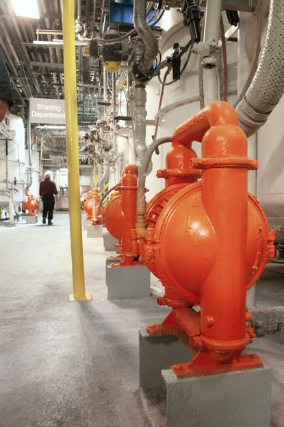 Safety pipes are painted bright orange in a warehouse. Safety pipes are painted bright orange in a warehouse.