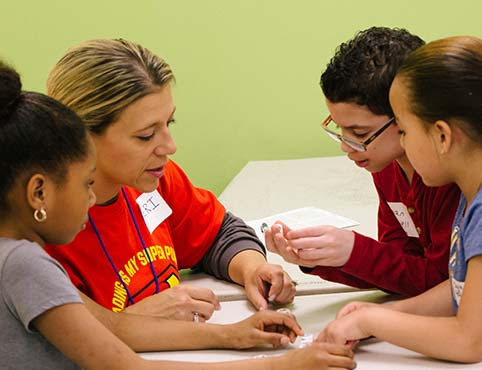 A Benjamin Moore volunteer reads with young children. A Benjamin Moore volunteer reads with young children.