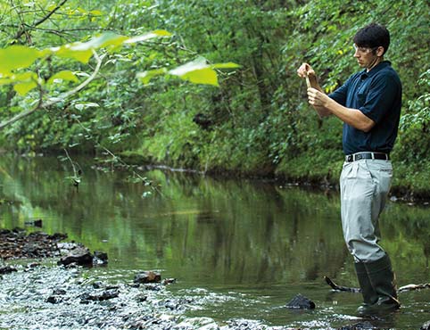 A Benjamin Moore employee tests water from a creek on our premises. A Benjamin Moore employee tests water from a creek on our premises.