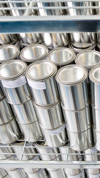 Unlabeled cans of Benjamin Moore paints, stacked. Unlabeled cans of Benjamin Moore paints, stacked.