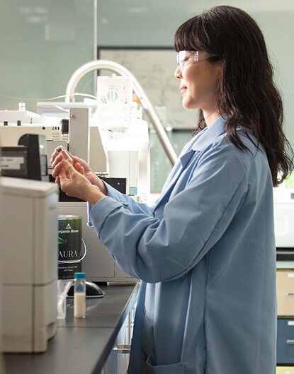 A female Benjamin Moore lab tech tests a sample of paint in a lab.