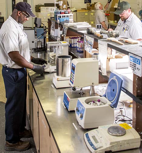 Benjamin Moore employees working on the quality control lab bench. Benjamin Moore employees working on the quality control lab bench.