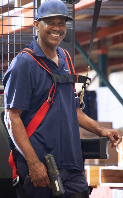 A Benjamin Moore employee enters the workplace with a smile, sporting a red backpack and baseball cap. A Benjamin Moore employee enters the workplace with a smile, sporting a red backpack and baseball cap.