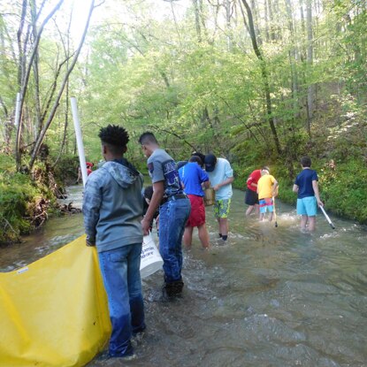 Young volunteers clean a river using Benjamin Moore buckets. Young volunteers clean a river using Benjamin Moore buckets.
