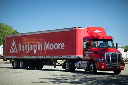 A large, red Benjamin Moore delivery truck.