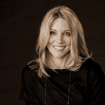 A head shot of a blonde woman with a black blouse.