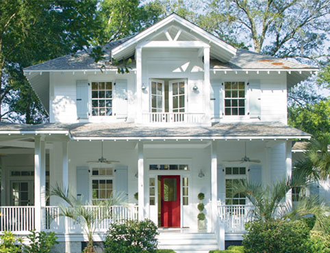 Traditional home with red door and wrap-around porch