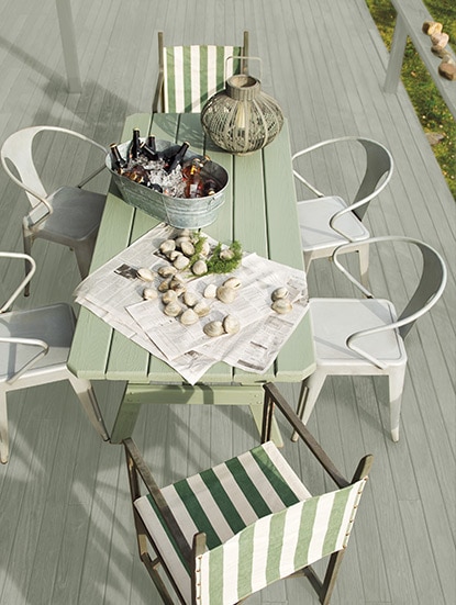 A light gray deck and mossy green wood table welcomes guests with a tub of icy beers and freshly caught clams. A light gray deck and mossy green wood table welcomes guests with a tub of icy beers and freshly caught clams.