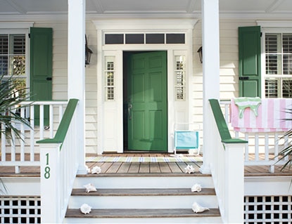 Green front door with matching window shutters