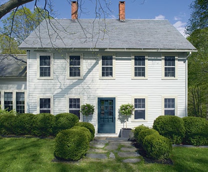 Colonial-style home with dark blue front door