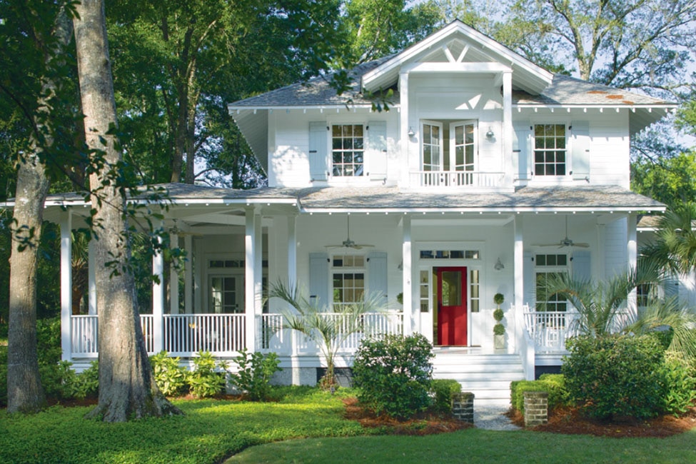 Traditional home with red door and wrap-around porch