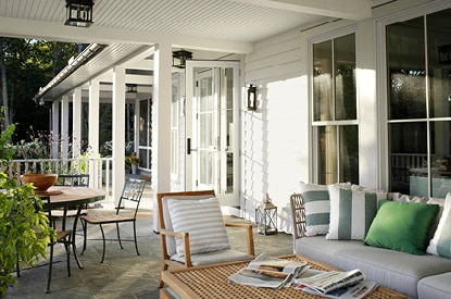 Covered patio with concrete flooring and multiple seating areas.