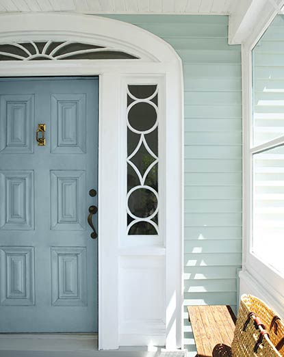 A home’s vinyl siding is painted in blue-gray with white-painted trim A home’s vinyl siding is painted in blue-gray with white-painted trim