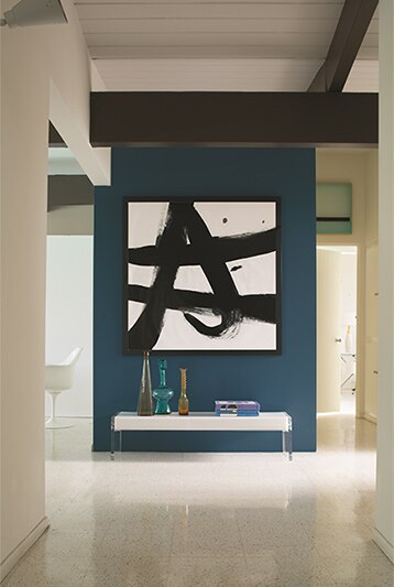 Modern hallway with teal blue accent wall featuring a large piece of white and black abstract artwork. Modern hallway with teal blue accent wall featuring a large piece of white and black abstract artwork.