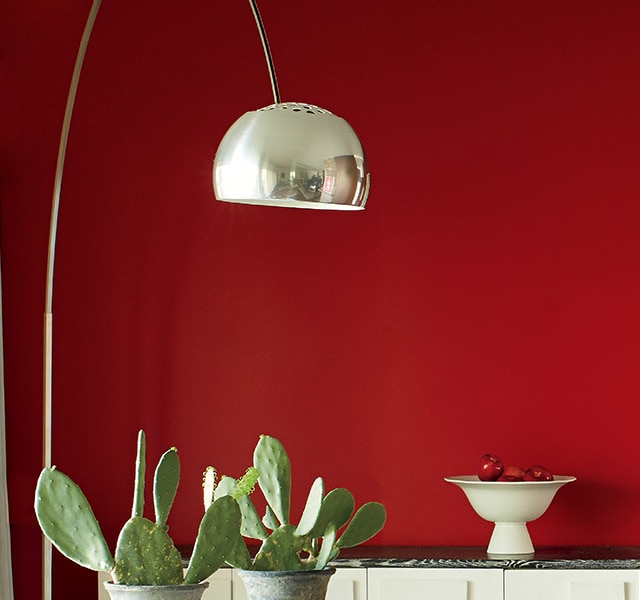 Une salle à manger contemporaine présentant un mur d’accent rouge.