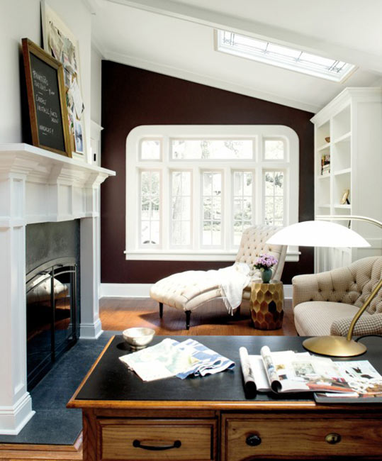 An elegant, bright office space with a large fireplace and a striking brown accent wall.