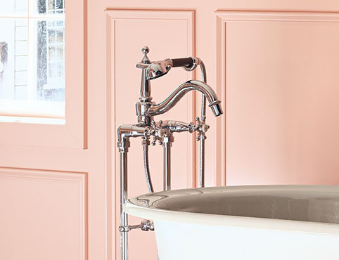 Baño rosado elegante con bañera con patas de garra, decoración francesa y acabados de Kohler.