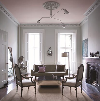 Un salon gris de style classique avec un plafond rose pâle et des fenêtres pleine longueur.