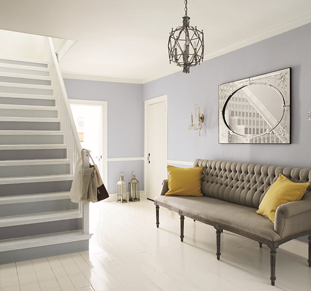 Entrada blanca y gris azulado claro con acentos de muebles clásicos. Entrada blanca y gris azulado claro con acentos de muebles clásicos.
