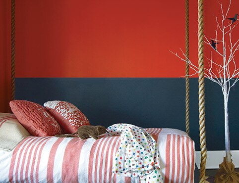 A kid's bedroom with a red and black painted wall features a swing bed. A kid's bedroom with a red and black painted wall features a swing bed.