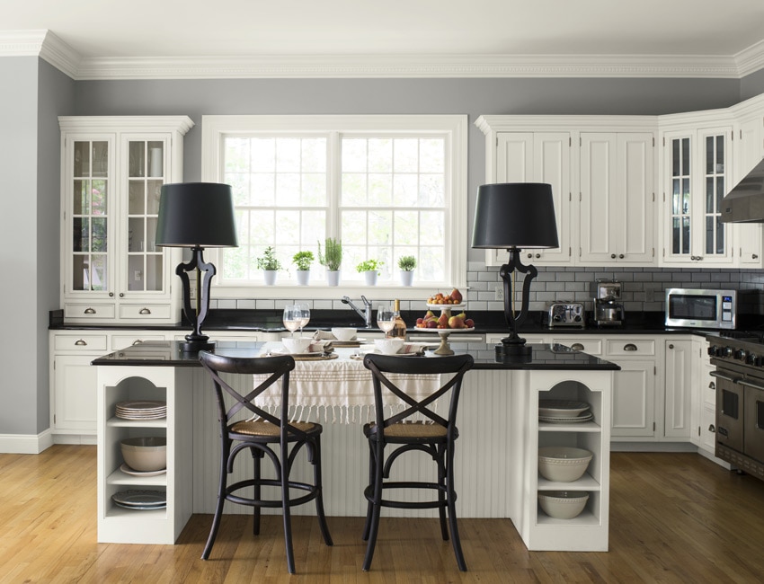 This light gray kitchen keeps it fresh with white cabinetry and subway tile backsplash, adding a dash of depth with black countertops.