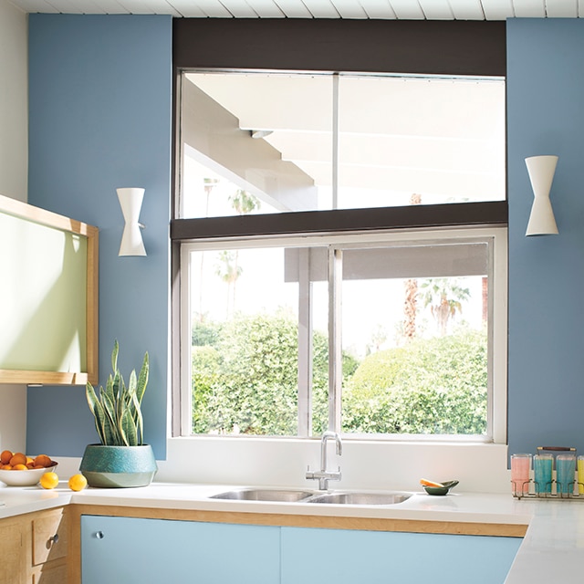 Cocina pintada en tonos de azules, con acentos de blanco y bronceado en gabinetes y mesadas.