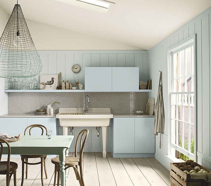 Sunny kitchen with blue walls, Kohler accents, ecelectic light fixture and hardwood floor