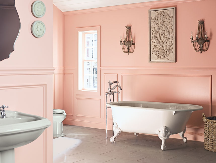 Chic pink bathroom with clawfoot tub and French décor and Kohler finishes