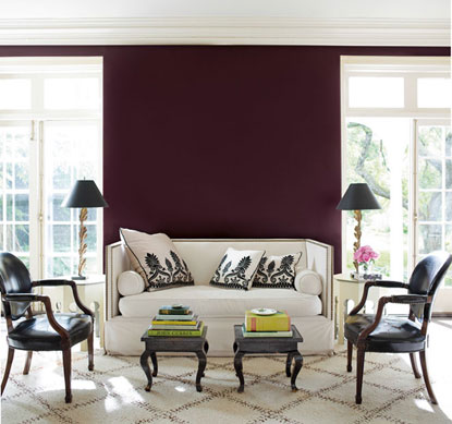 Clean living room with dark purple wall and black side chairs