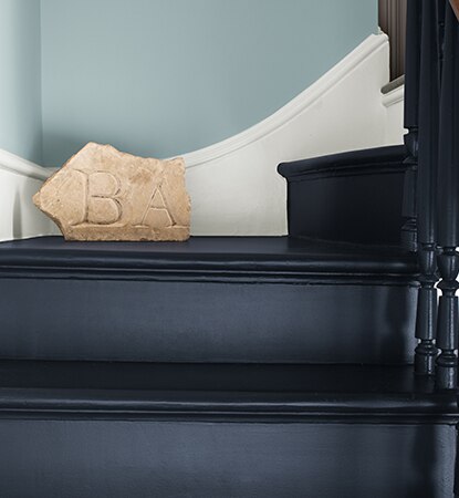 Sleek navy staircase with white trim against pale blue walls.