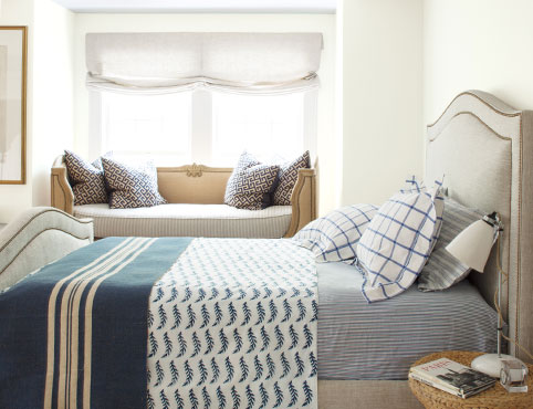 Bedroom with nautical-inspired blue striped rug and walls painted in Icicle OC-60.