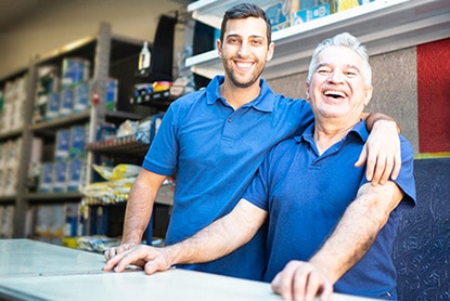 Une équipe de détaillants, père et fils, derrière le comptoir de leur magasin Benjamin Moore.