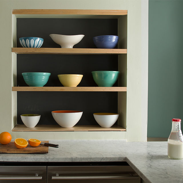 A kitchen with a yellow, yellow-green and green colour combination using muted hues.