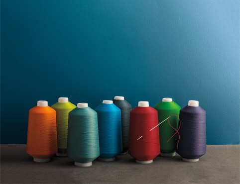Multicoloured sewing spools reflect the accentuated response to light found in Aura® Colour Stories®.