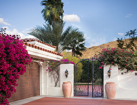 Gated driveway on a southwestern style home overlooking a scenic mountain range.