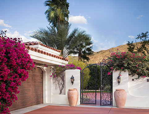 Entrada con portón en una casa de estilo suroeste con vista a una pintoresca cadena montañosa.