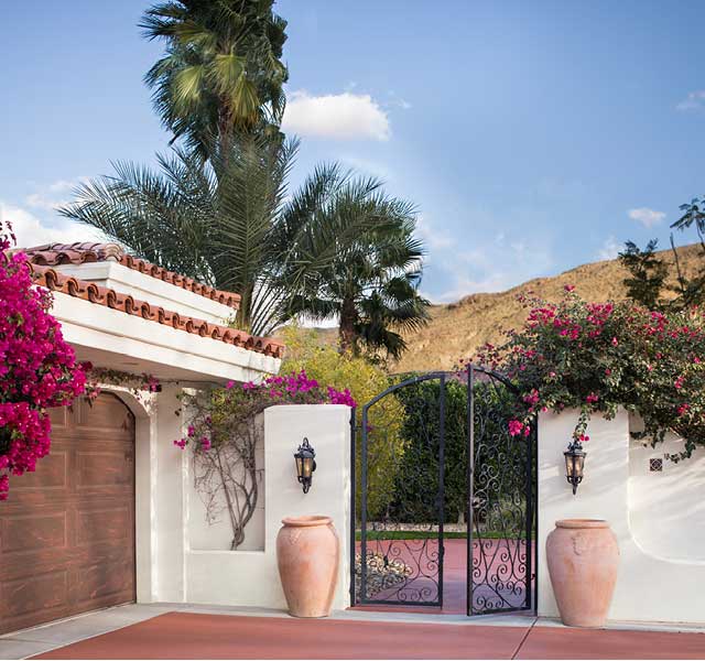 Entrada con portón en una casa de estilo suroeste con vista a una pintoresca cadena montañosa.