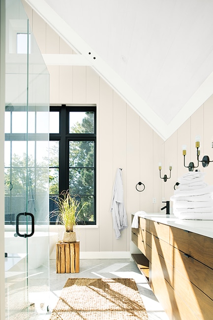 Baño soleado con techo pintado en Blanco Brillante OC-150, paredes con paneles en Perla Marina OC-19 y ventana con marco negro.